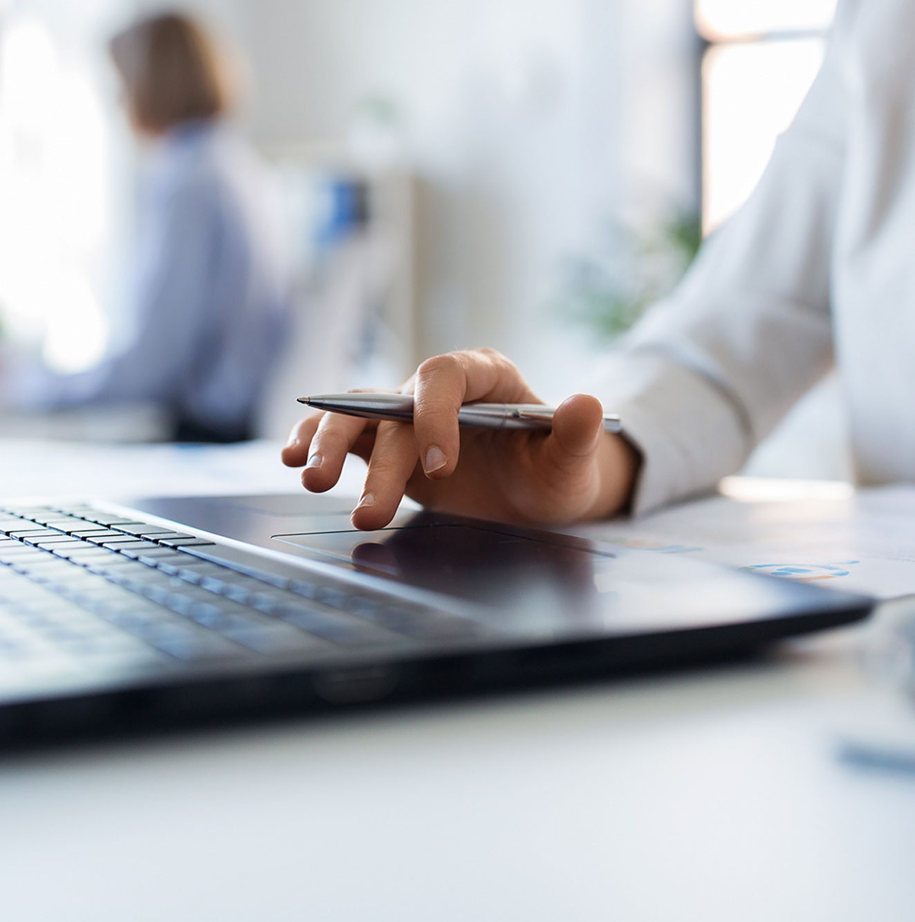 Eine Frauenhand die am Laptop arbeitet.